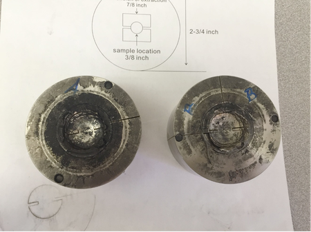 Two impact-cratered target assemblies. The overall chamber is made of stainless steel. Rock samples are placed in the center of the chamber. The black stains are from decomposed plastic sabot and O-rings of the projectile. 