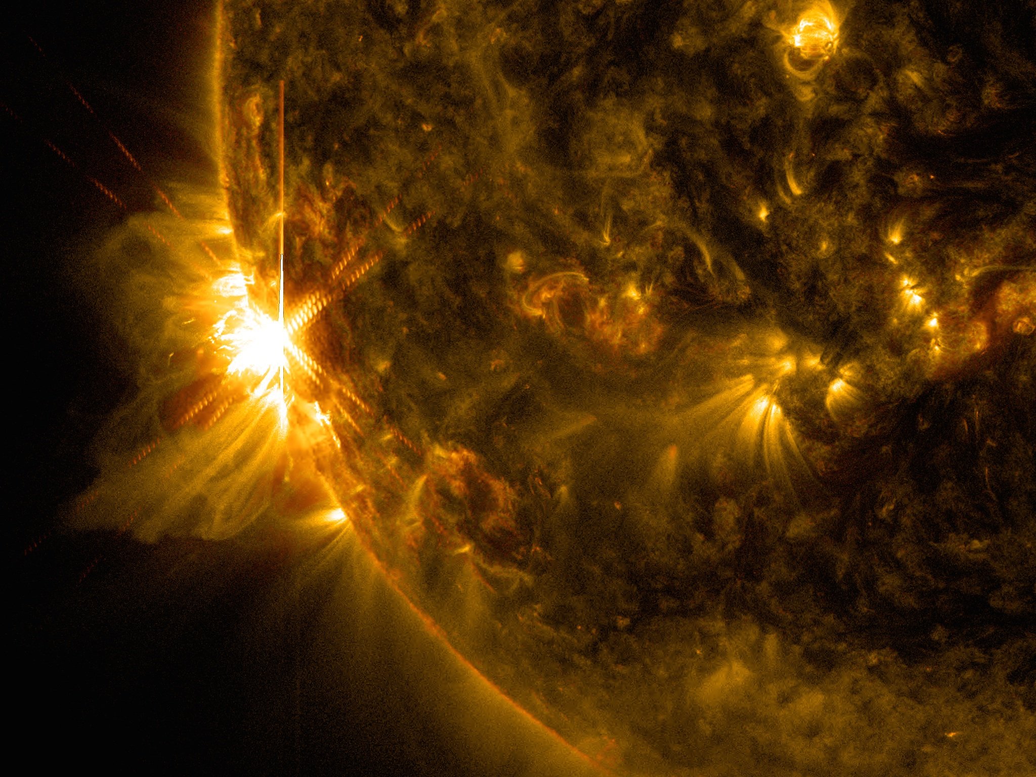 A solar flare bursts off the left limb of the sun in this image captured by NASA's Solar Dynamics Observatory. 