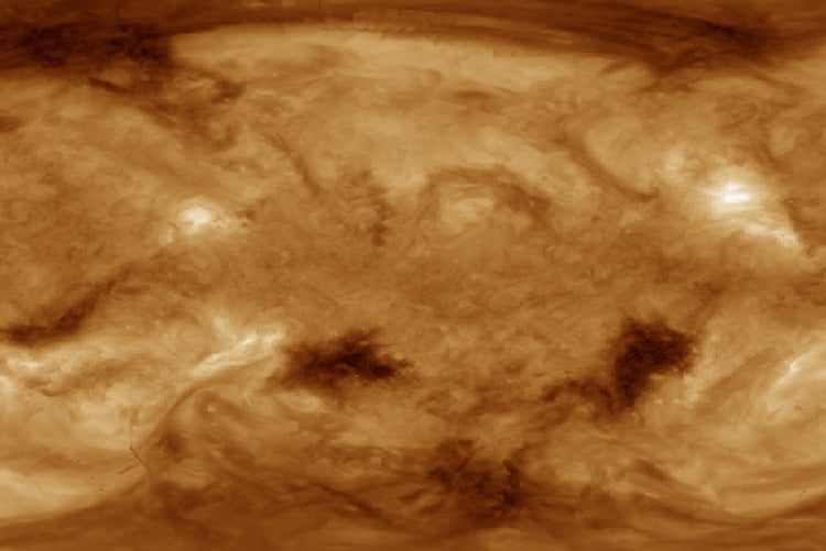 A flattened map of the sun’s entire surface, or corona, imaged in extreme ultraviolet wavelengths by the NASA Solar Dynamics Observatory (SDO) satellite. The two dark regions below the middle of the image are the coronal holes sampled by the Parker Solar Probe. Within these coronal holes, flows in the solar atmosphere create intense, complex magnetic fields that annihilate and produce the pressure and energy to overcome solar gravity and send high-energy particles outward — the fast solar wind.