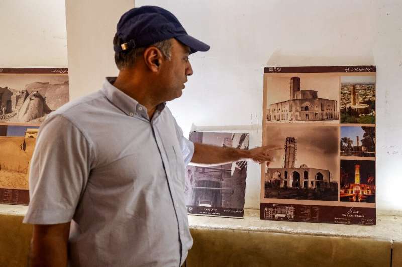 A cultural heritage specialist gives a briefing on the wind-catcher of Dowlat Abad Garden, the world's tallest