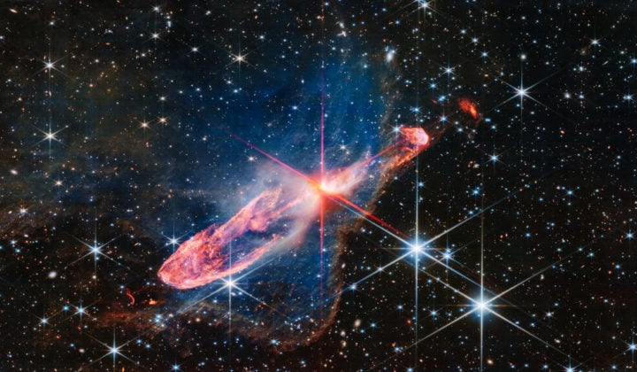 James Webb Space Telescope has captured a tightly bound pair of actively forming stars, known as Herbig-Haro 46/47, in high-resolution near-infrared light. Look for them at the center of the red diffraction spikes, appearing as an orange-white splotch. Herbig-Haro 46/47 is an important object to study because it is relatively young – only a few thousand years old. Star systems take millions of years to fully form. Targets like this give researchers insight into how much mass stars gather over time, potentially allowing them to model how our own Sun, which is a low-mass star, formed – along with its planetary system.