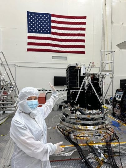 JPL Director Laurie Leshin poses with SPHEREx at JPL. The instrument is mounted to a vibration table for simulating shaking during launch. 