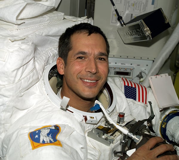 Astronaut John B. Herrington wears a spacesuit aboard the International Space Station in 2002. The pack on his back is full of important life-support equipment, such as an environmental control system to protect against the extreme temperatures of space. Work on this system inspired former NASA contractor Mark Aramli to develop the BedJet system. 