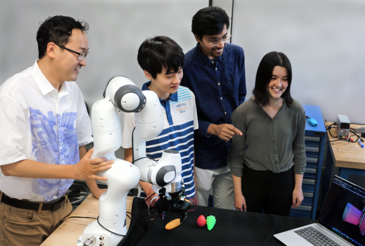 Robotics professor Ye Zhao (GT-ME), high school intern Matthew Zhu, graduate student Chaitanya Mehta, and high school intern Christian Hable with the lab's robotic arm with tactile sensors. 