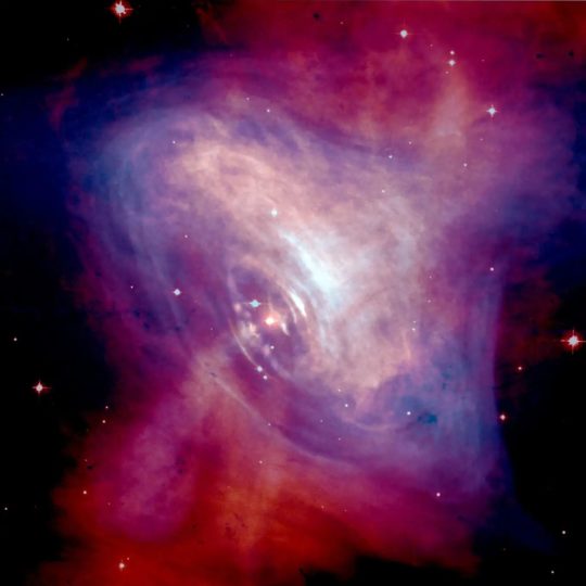 The Crab Nebula – a remnant of a supernova explosion which in its center contains a pulsar. The pulsar makes the ordinary matter in the form of gas in the nebula light up. As the researchers have now shown, it may do the same with dark matter in the form of axions, leading to a subtle additional glow that can be measured. 