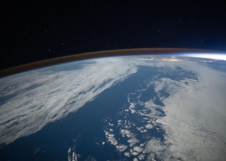 The airglow blankets the Earth’s horizon during an orbital sunset in this photograph from the International Space Station as it orbited 262 miles above the Pacific Ocean southwest of California. 