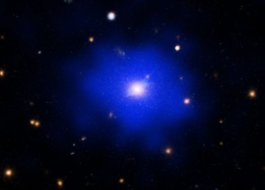 This composite image shows SPT-CL J2215-3537 (SPT2215 for short) in X-rays from NASA’s Chandra X-ray Observatory (blue) and a combination of ultraviolet, optical, and infrared light from NASA’s Hubble Space Telescope (cyan and orange).