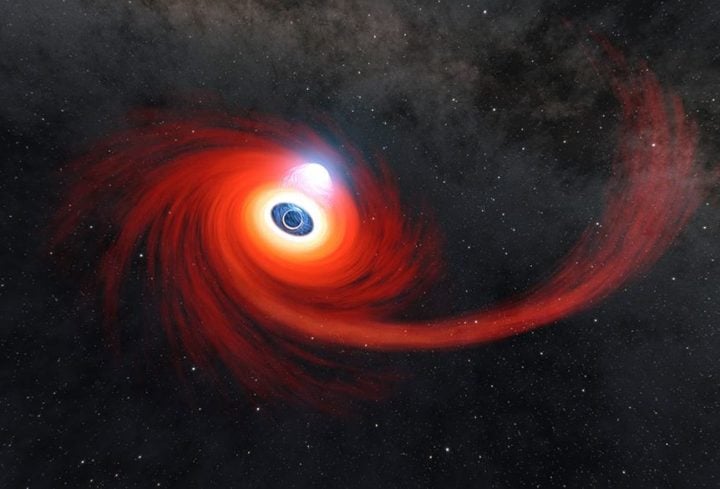 A disk of hot gas swirls around a black hole in this illustration. The stream of gas stretching to the right is what remains of a star that was pulled apart by the black hole. A cloud of hot plasma (gas atoms with their electrons stripped away) above the black hole is known as a corona. Image Credit: NASA/JPL-Caltech