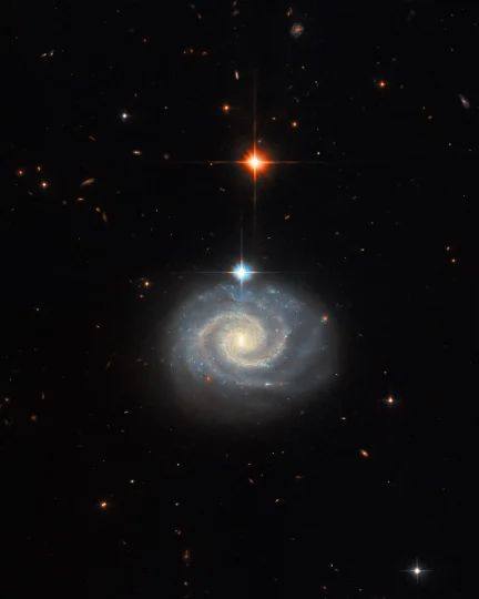 This NASA Hubble Space Telescope image features a bright spiral galaxy known as MCG-01-24-014, which is located about 275 million light-years from Earth.