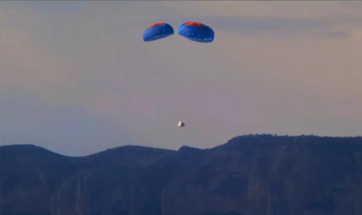The New Shepard crew capsule descends under parachutes during its launch Tuesday, Dec. 19, 2023.