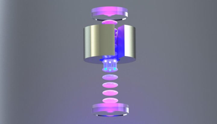 Physicists at UC Berkeley immobilized small clusters of cesium atoms (pink blobs) in a vertical vacuum chamber, then split each atom into a quantum state in which half of the atom was closer to a tungsten weight (shiny cylinder) than the other half (split spheres below the tungsten). By measuring the phase difference between the two halves of the atomic wave function, they were able to calculate the difference in the gravitational attraction between the two parts of the atom, which matched what is expected from Newtonian gravity. 