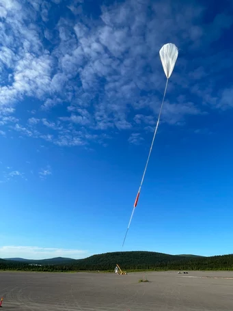 The helium balloon slowly rises into the air. 