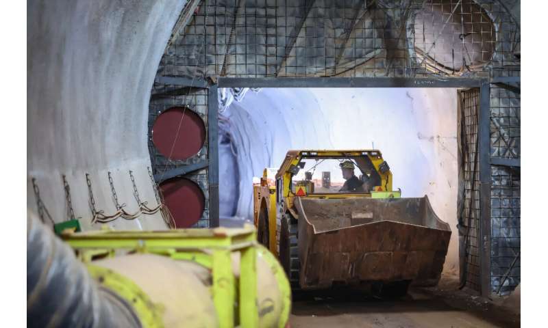 A bucket loader drives through an underground tunnel of the Konrad site