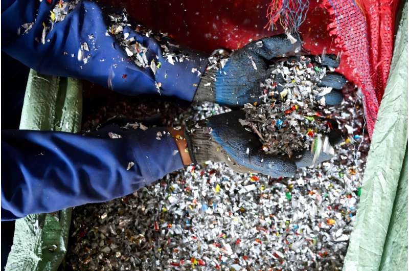 A worker sorts shredded recyclable plastic waste at the Green Road Waste Management processing facility in Pokhara