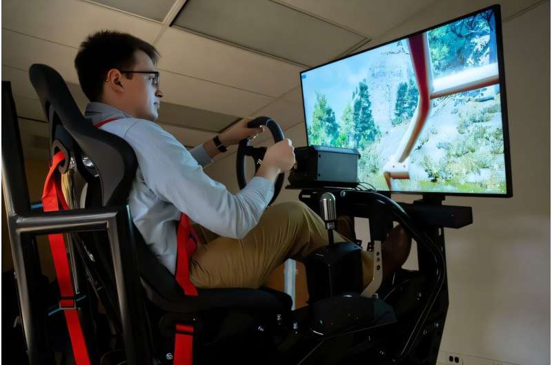 Graduate student James Baxter conducts motion-based driving simulation trials. The Digital Engineering testbed enables driver feedback studies and vehicle dynamics evaluation under varied terrain conditions. Credit: Levi Hutmacher/Michigan Engineering Off-road autonomy and digital twins