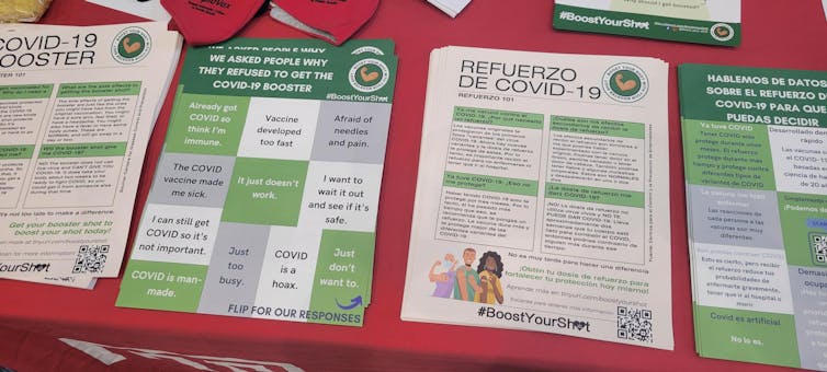 Green, white and gray educational materials in small stacks on a table