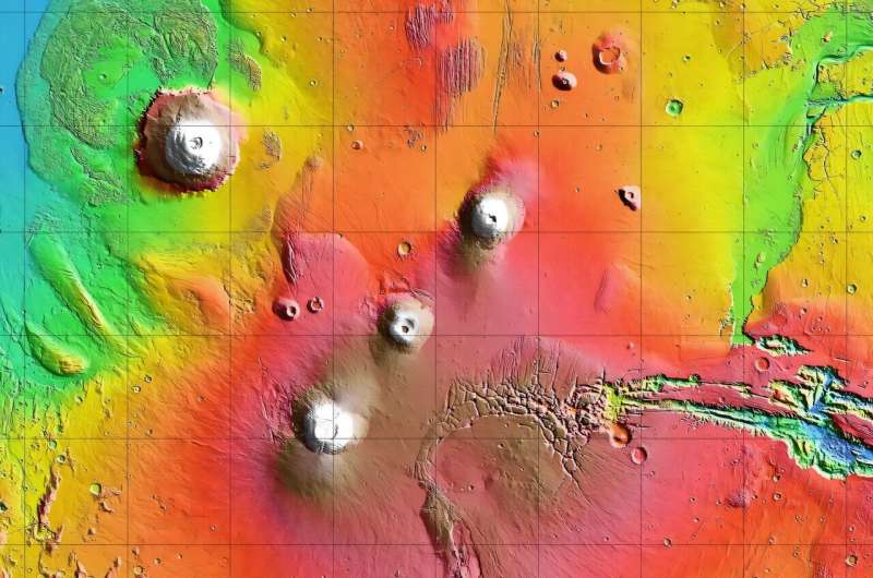 Arsia Mons is the southernmost of the three volcanoes that make up Tharsis Montes, shown in the center of this cropped topographic map of Mars. Olympus Mons, the solar system’s largest volcano, is at upper left. The western end of Valles Marineris begins cutting its wide swath across the planet at lower right. Credit: NASA/JPL-Caltech NASA Mars Orbiter Captures Volcano Peeking Above Morning Cloud Tops