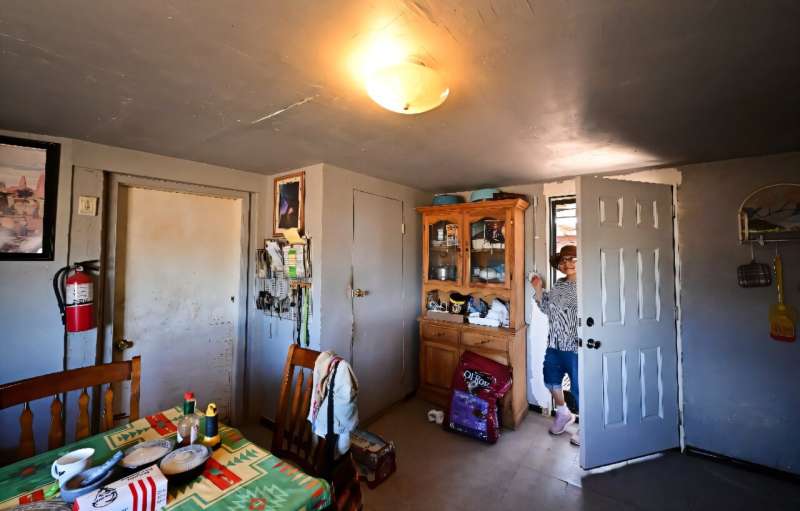 Christine Shorty, 70, turns on a light for the first time in her home after it was connected to the power grid. Christine Shorty, 70, turns on a light for the first time in her home after it was connected to the power grid