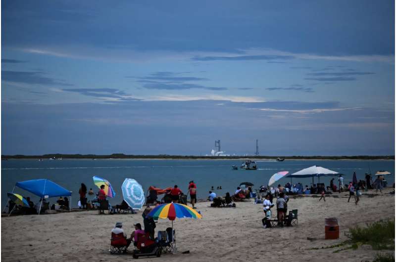 People sit on the beach in South Padre Island, Texas, preparing to watch the scrubbed launch. People sit on the beach in South Padre Island, Texas, preparing to watch the scrubbed launch