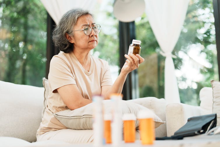 Woman examining a medicine bottle