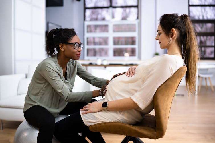 Pregnant woman in a home having a massage from a non-medical caregiver.
