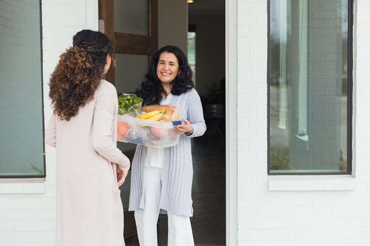 Woman delivering groceries to a neighbor