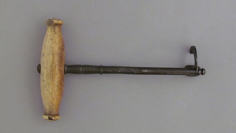 tool with wooden handle and metal hook on opposite end