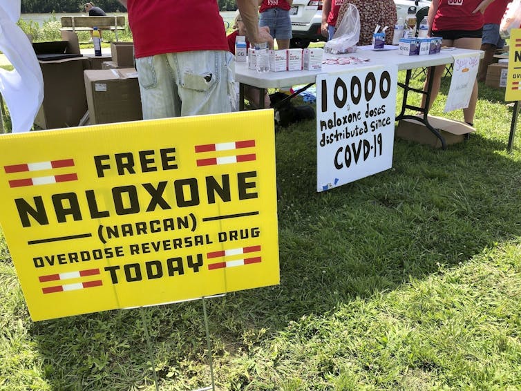 Signs are displayed at a tent during a health event in 2021 in Charleston, W.Va.