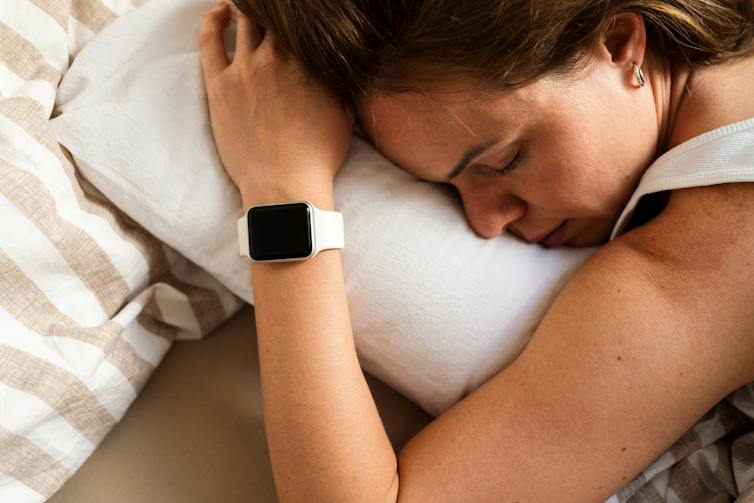 Woman asleep with smartwatch on wrist.